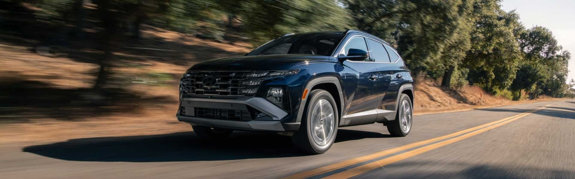 Hyundai Tucson driving on a scenic road.